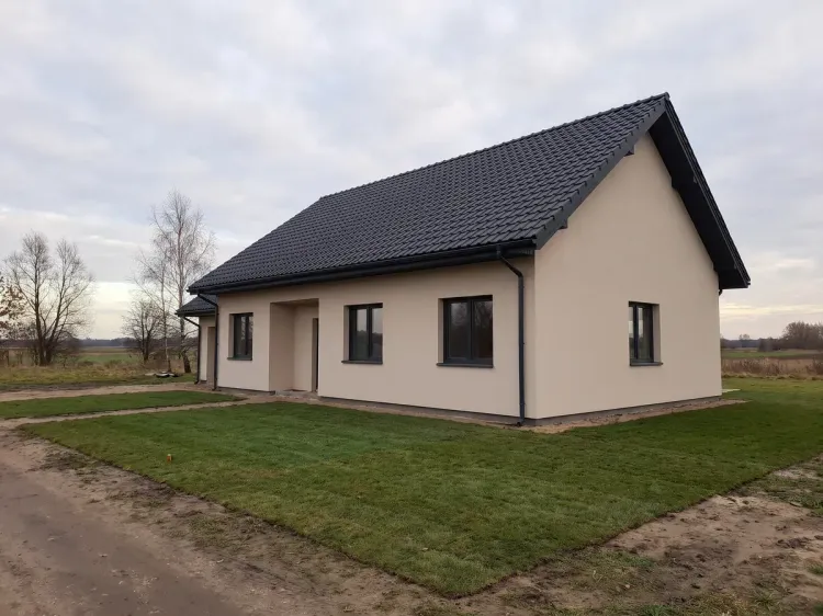Dom parterowy po ociepleniu, elewacja w jasnym tynku silikonowym